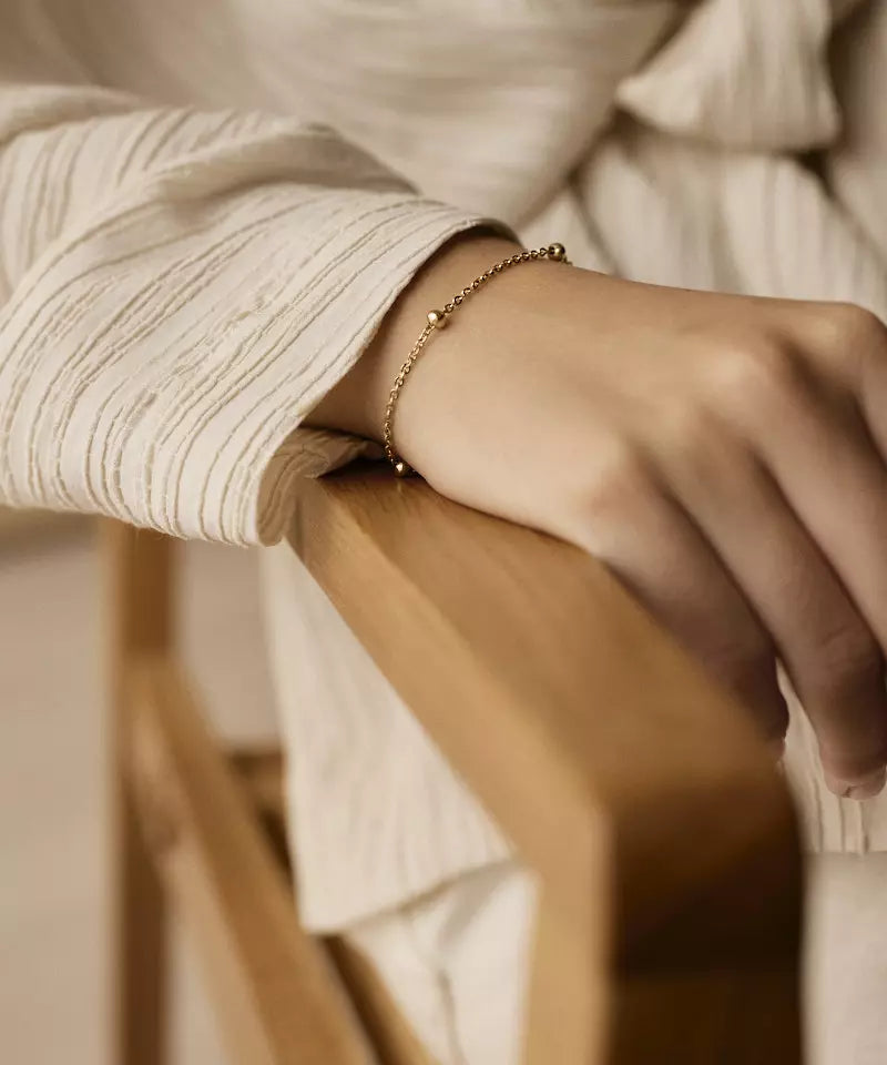 Gullhúðað armband með kúlum.